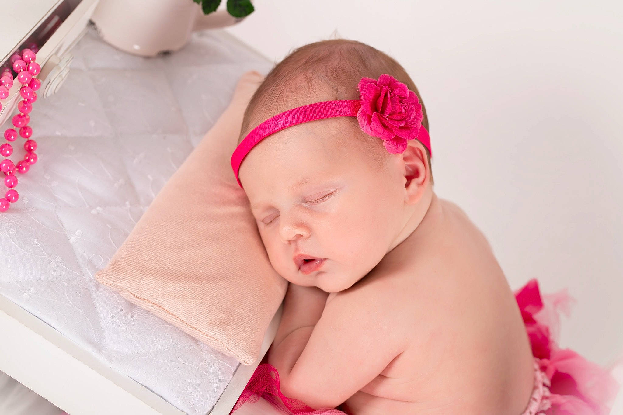 Gyulia participe au concours pour gagner de l'argent avec cette photo : baby, baby_products, baby_sleeping, baby_toddler_clothing, comfort, face, fashion_accessory, goggles, hair_accessory, happy, head, headband, headgear, headpiece, houseplant, linens, magenta, person, pink, skin