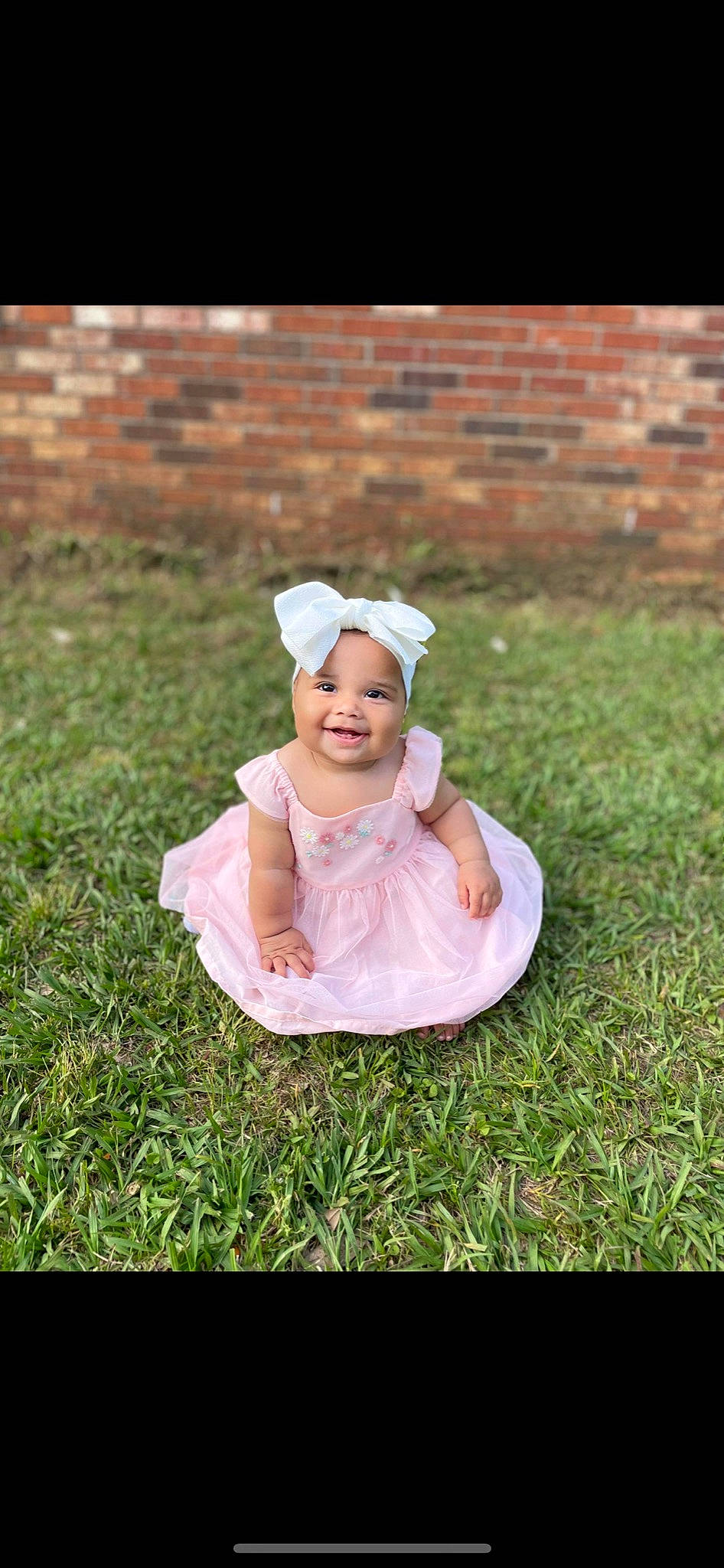Emberly is registered to the contest to win money with this photo: baby, baby_toddler_clothing, brick, child, flash_photography, garden, grass, grass_family, grassland, happy, hat, headgear, headwear, joy, lawn, people_in_nature, person, plant, recreation, sitting