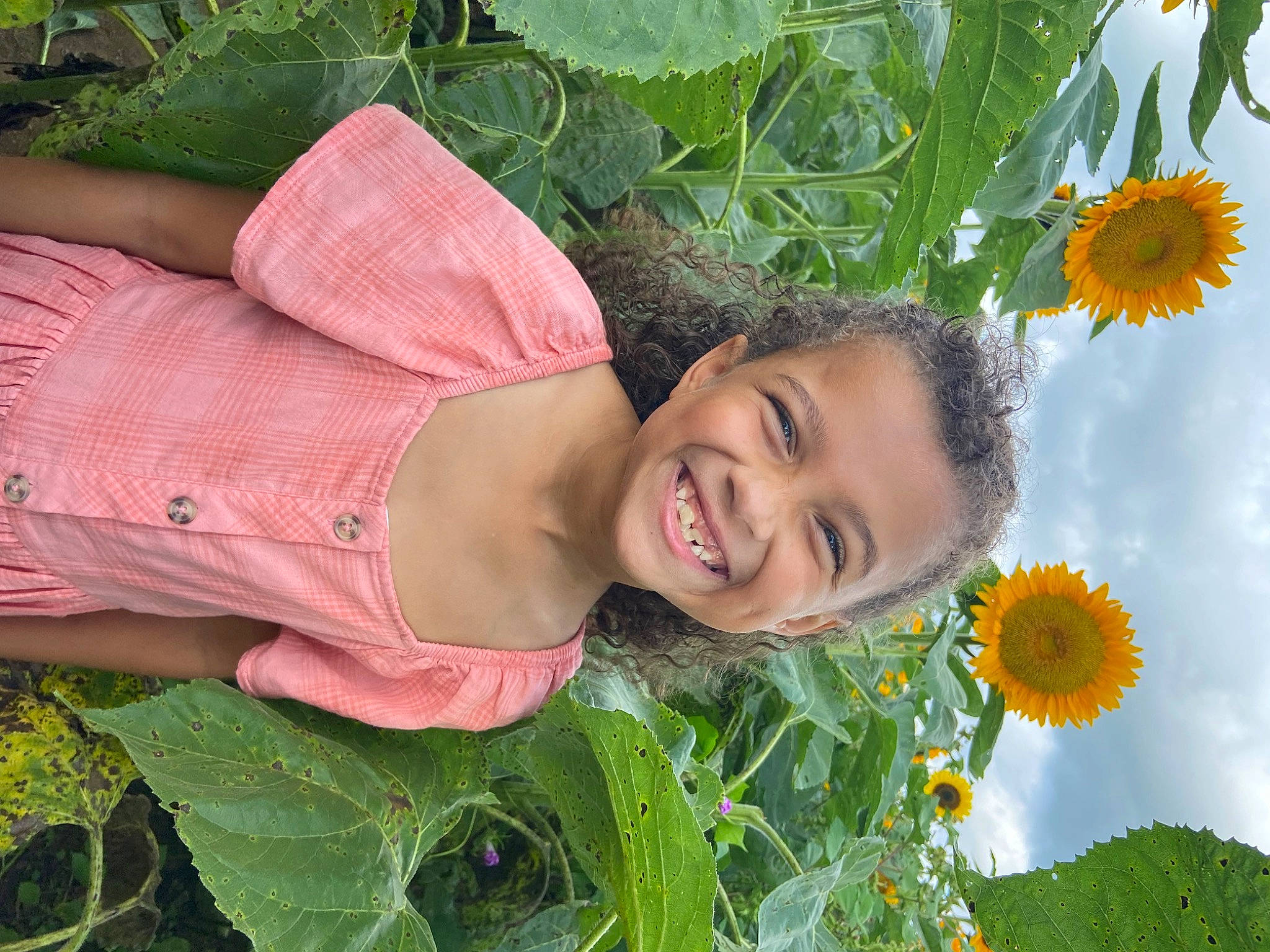 Janiya is registered to the contest to win money with this photo: annual_plant, botany, child, field, flower, flowering_plant, grass, grassland, green, happy, joy, leaf, people_in_nature, person, petal, plant, plantation, pollen, prairie, smile
