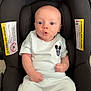 Zayden joined the competition — help win amazing prizes! baby, infant, car_seat, white_clothing, mickey_mouse, surprised_expression, child, cute, indoors, seat_belt, black_car_seat, small_hands, legs, head, portrait, person, young_child, sitting, expression, clothing