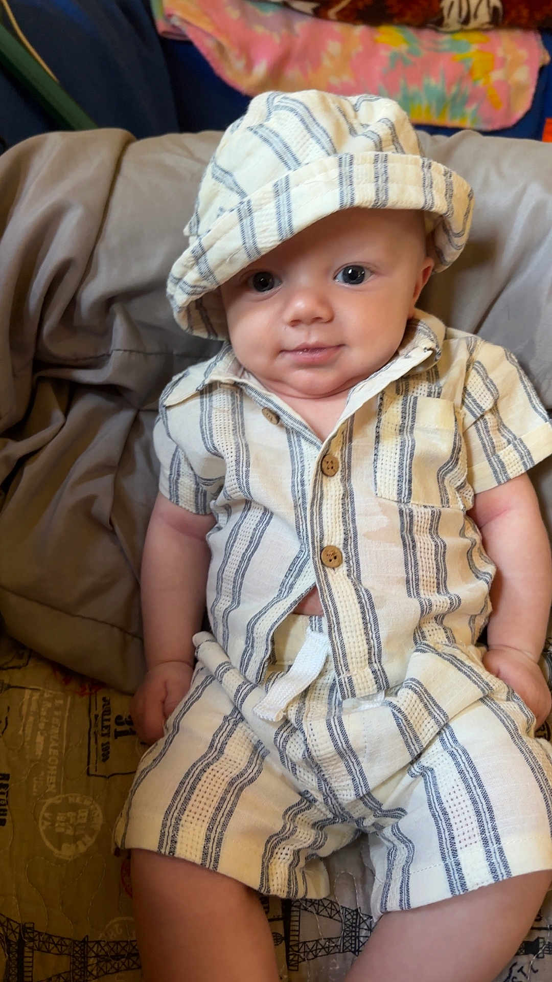 Zayden joined the competition — help win amazing prizes! baby, child, infant, hat, striped_clothing, shorts, shirt, bed, blanket, smile, face, person, cute, indoors, skin, eyes, hand, legs, comfortable, relaxed