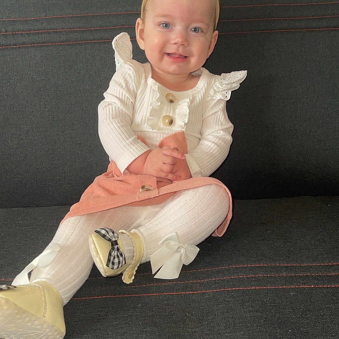 Louane a rejoint le concours — aidez-le/la à gagner de superbes lots ! baby, bow, child, couch, cute, fashion, girl, happy, headband, home, indoor, infant, peach_skirt, person, portrait, shoes, sitting, smiling, tights, white_clothing