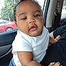 Ami is registered to the contest to win money with this photo: baby, child, infant, portrait, car, vehicle, backseat, sitting, white_shirt, blue_shorts, short_hair, face, eyes, mouth, curious, outdoor, trees, red_car, daylight, photography
