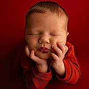 Bastien participe au concours pour gagner de l'argent avec cette photo : baby, sleeping, red_background, red_sweater, hands, face, infant, cozy, portrait, closeup, peaceful, rest, cute, child, newborn, soft_light, warm_colors, young, calm, studio
