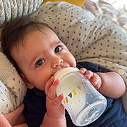 Zaïen participe au concours pour gagner de l'argent avec cette photo : baby, bottle, feeding, pajamas, pink, hello_kitty, pillow, blanket, cute, child, face, hand, indoor, clothing, soft, cozy, infant, person, portrait, resting