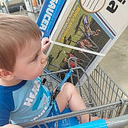 John joined the competition — help win amazing prizes! toddler, child, shopping_cart, store, retail, indoor, sitting, profile, face, brown_hair, blue_shirt, shopping, walmart, chair_display, outdoor_furniture, cart, baby, curious, store_aisle, portrait
