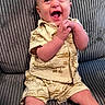 baby, child, clothing, couch, cute, fabric, face, hands, happy, head, indoors, infant, laughing, patterned_outfit, person, portrait, sitting, smiling, texture, young_child