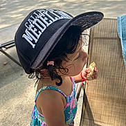 Ysabell is registered to the contest to win money with this photo: cap, casual, chair, child, clothing, curly_hair, daylight, food, hat, outdoor, person, playtime, pool, relaxation, side_view, snack, summer, sunlight, toddler, young_child