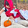 Ysabell is registered to the contest to win money with this photo: baby, child, costume, red_hood, pumpkin, blanket, tree, autumn, outdoor, nature, basket, white_cloth, fall_leaves, cute, sitting, portrait, soft_texture, curious, footwear, colorful