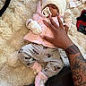 Laelani is registered to the contest to win money with this photo: baby, sleeping, pacifier, hat, pink_clothing, gray_pants, minnie_mouse, hand, tattoo, nail_art, fluffy_rug, soft_texture, cute, cozy, infant, gloves, footwear, indoor, person, toddler