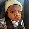 baby, infant, hat, car_seat, straps, wide_eyes, curious, clothing, child, seatbelt, portrait, indoors, cute, headwear, person, young_child, close_up, expression, face, sitting