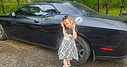 Alexa joined the competition — help win amazing prizes! accessory, black_car, car, child, cute, daylight, footwear, girl, greenery, happy, nature, outdoor, peace_sign, plaid_dress, posing, road, smiling, trees, vehicle, wheel