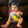baby, child, smiling, sitting, flower, bow, headband, couch, leather, clothing, red, blue, yellow, happy, indoor, cute, portrait, skin, person, toddler