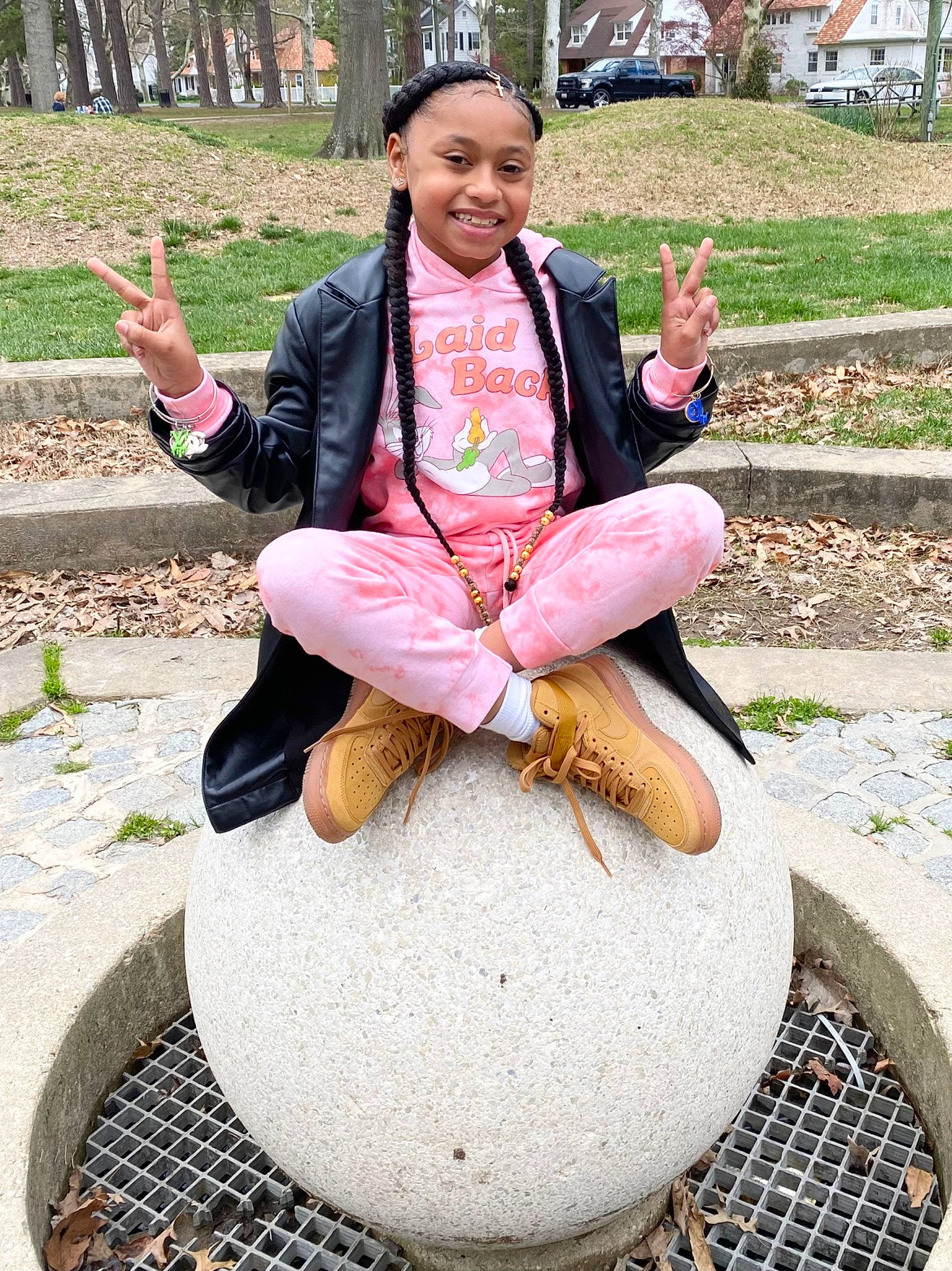 Kimorah is registered to the contest to win money with this photo: art, fun, gesture, grass, green, hand, happy, headwear, joy, lawn_ornament, leg, leisure, person, photograph, pink, plant, recreation, sculpture, shoe, sitting