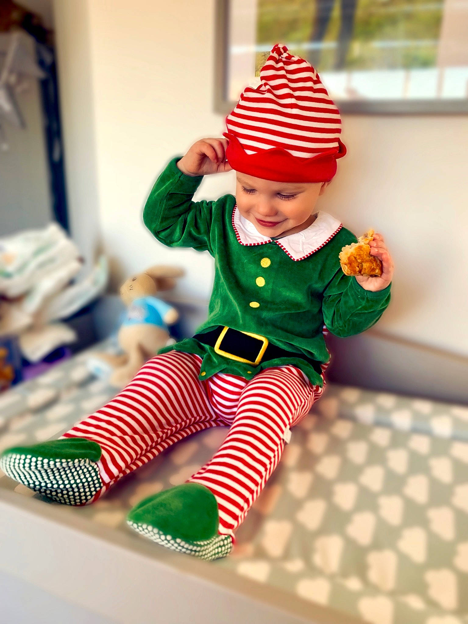 Benny is registered to the contest to win money with this photo: child, christmas, christmas_elf, christmas_eve, costume, fictional_character, green, headgear, headwear, holiday, joy, pajamas, person, sleeve, toddler