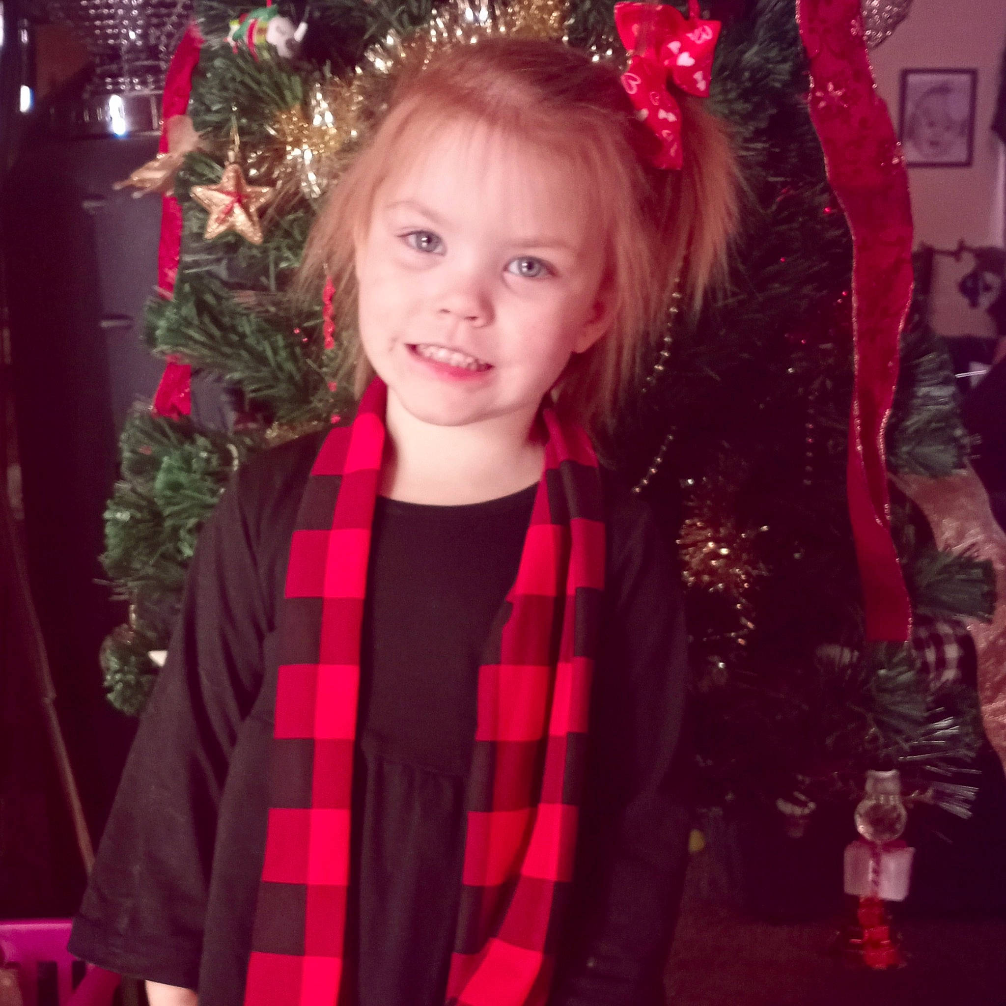 Kaitlyn joined the competition — help win amazing prizes! christmas, christmas_decoration, christmas_ornament, christmas_tree, face, facial_expression, fashion, hairstyle, happy, holiday, holiday_ornament, human_body, joy, person, pink, plaid, red, sleeve, smile, standing