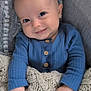 baby, infant, smile, blue_clothing, knit_blanket, hand, face, cozy, cute, portrait, child, sitting, indoors, warm, soft_texture, buttoned_shirt, closeup, happy, young, candid