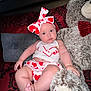 Valeria is registered to the contest to win money with this photo: baby, infant, heart_pattern, headband, teddy_bear, plush_toy, couch, pillow, red, white, skin, face, foot, hand, clothing, smile, indoor, cute, child, portrait