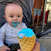 Swann participe au concours pour gagner de l'argent avec cette photo : baby, blue_ice_cream, blurred_background, casual_clothing, child, cone, daylight, expression, face, food, hand, ice_cream, messy, mouth, outdoor, person, stroller, summer, sweet, toddler