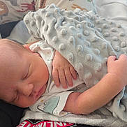 Kade is registered to the contest to win money with this photo: newborn, baby, sleeping, blanket, hand, soft_texture, cushion, animal_print, cozy, infant, cute, resting, peaceful, indoors, child, person, comfort, closeup, portrait, sleep