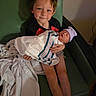 Kade is registered to the contest to win money with this photo: child, newborn, baby, hospital, blanket, hat, chair, sibling, smile, indoor, person, holding, family, cute, love, toddler, portrait, hospital_room, comfort, caring