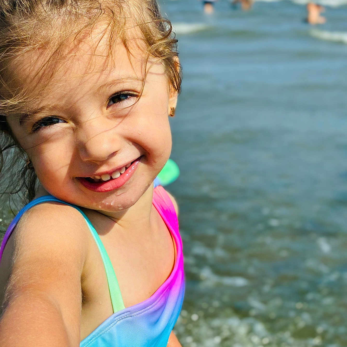 Saphia is registered to the contest to win money with this photo: beach, child, face, fun, girl, happy, ocean, outdoor, playful, portrait, rainbow_colors, skin, smiling, summer, sunlight, swimsuit, vacation, water, waves, young
