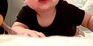 Mallory joined the competition — help win amazing prizes! baby, infant, child, crawling, black_shirt, wide_eyes, indoor, soft_surface, curious, tousled_hair, person, young_child, face, hands, expression, closeup, home, playpen, background, light