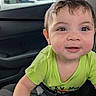 baby, child, infant, face, smile, curious, green_shirt, car_interior, seat, window, vehicle, young_child, portrait, cute, happy, indoors, closeup, person, skin, eyes
