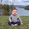 baby, child, grass, outdoor, lake, water, trees, nature, sky, clouds, cute, sitting, clothing, long_sleeve, pants, socks, portrait, young_child, smile, daytime