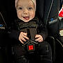 Carter is registered to the contest to win money with this photo: baby, smiling, car_seat, pink_bow, infant, child, black_clothing, safety_harness, graco, trueshield, cute, happy, tongue_out, seatbelt, indoor, person, headband, closeup, small_hands, footwear