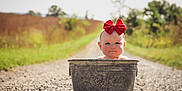 Addy is registered to the contest to win money with this photo: asphalt, cap, child, eye, eyewear, fashion_accessory, flash_photography, fun, grass, grassland, happy, head, landscape, prairie, road, sitting, sky, soil, toddler, wood