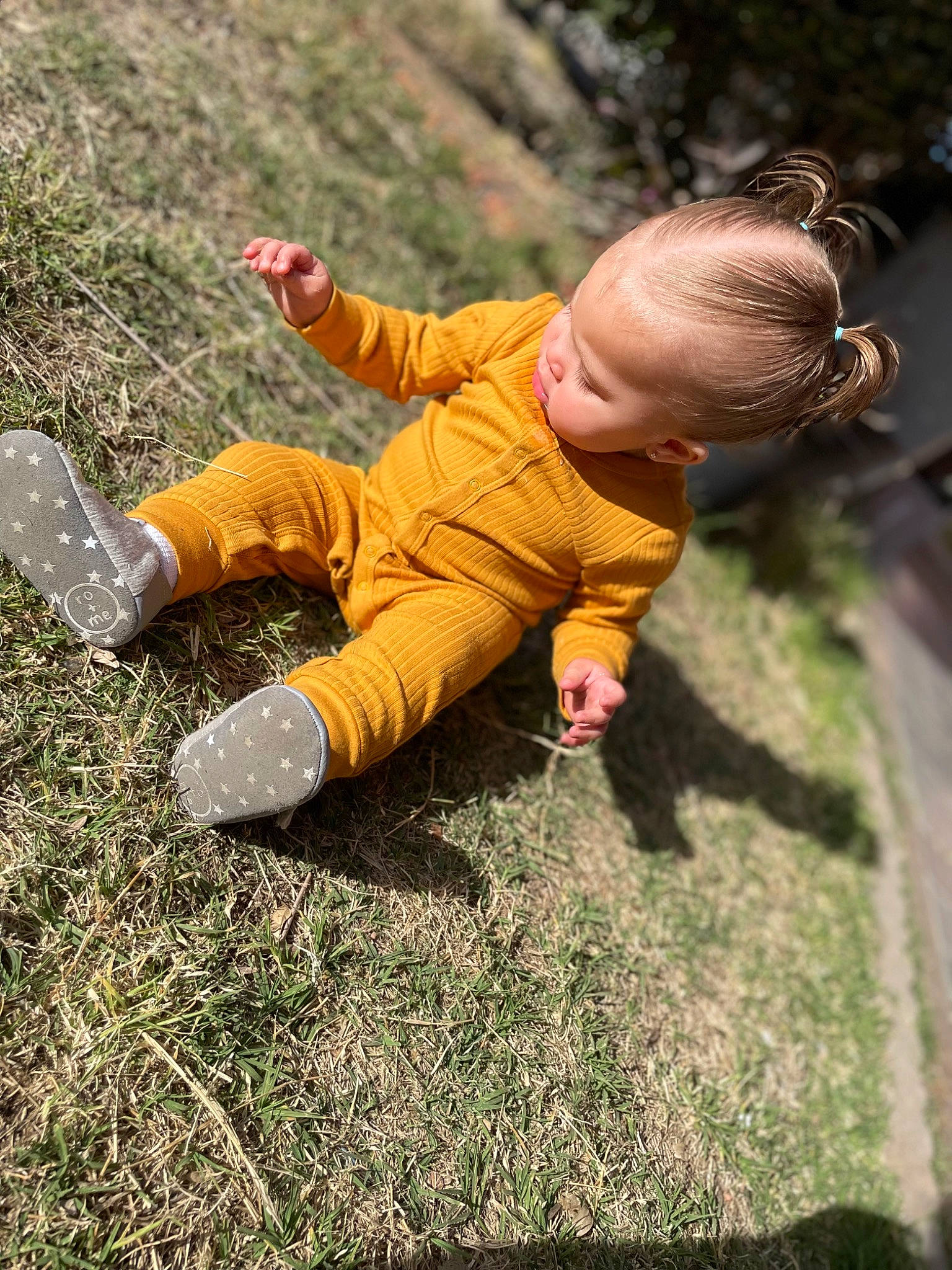 Malayah is registered to the contest to win money with this photo: baby, baby_toddler_clothing, boot, fun, grass, grassland, happy, jacket, landscape, leisure, people_in_nature, person, plant, recreation, rock, sitting, sneakers, soil, toddler, tree