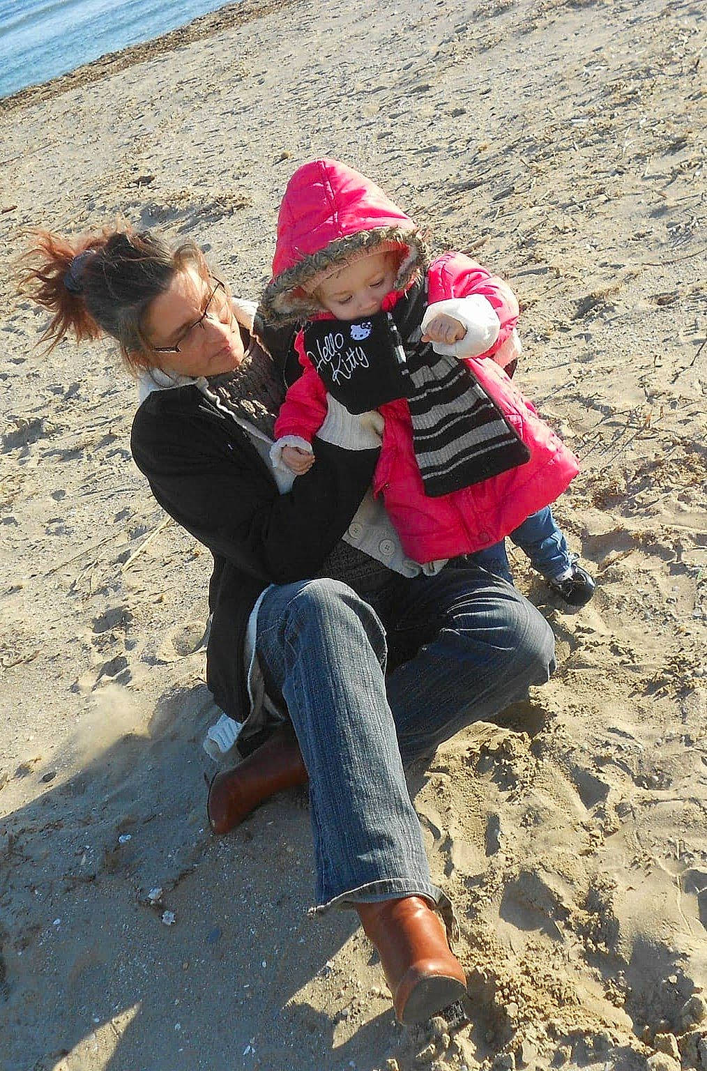 Alyssa participe au concours pour gagner de l'argent avec cette photo : beach, body_of_water, eyewear, foot, fun, geology, happy, headwear, jeans, landscape, leg, leisure, people_in_nature, person, rock, sand, shoe, sitting, soil, summer