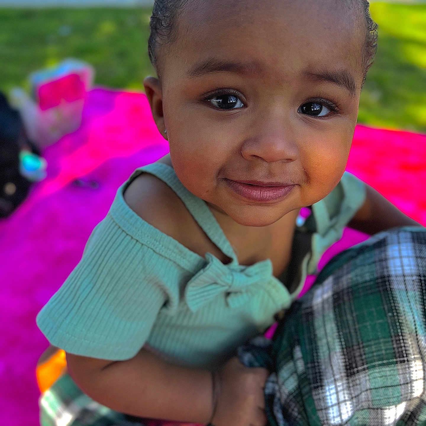 Araia is registered to the contest to win money with this photo: baby, bodypart, clothing, dress, face, finger, grass, hand, happy, head, mouth, person, photography, plant, portrait, purple, shirt, shorts, smile, teeth