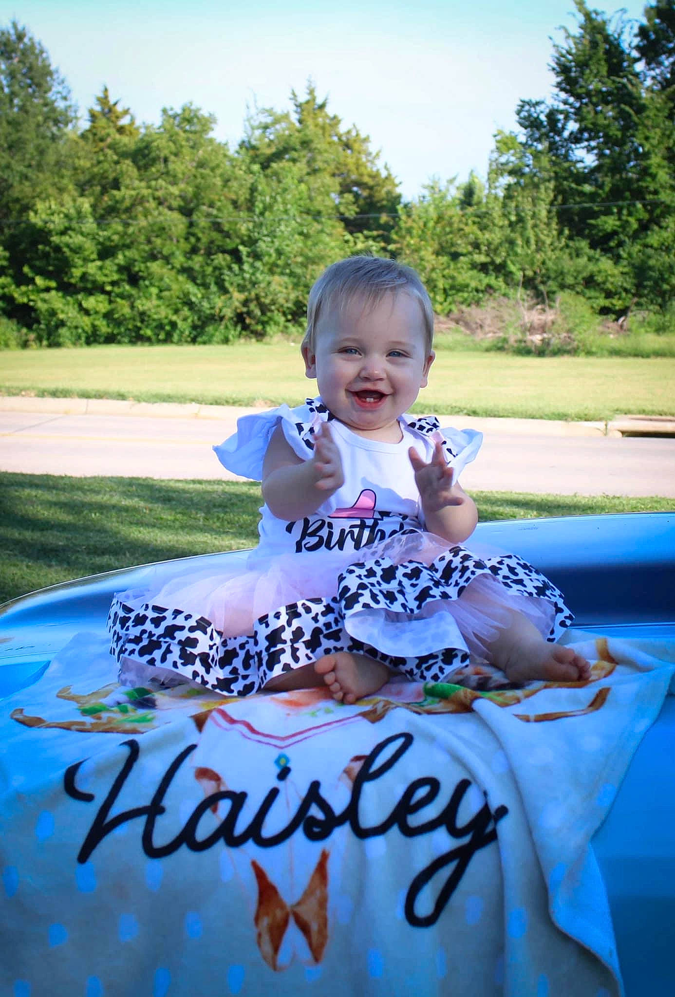 Haisley is registered to the contest to win money with this photo: baby, baby_toddler_clothing, child, electric_blue, event, fun, grass, happy, joy, leisure, person, plant, play, recreation, sitting, sky, smile, summer, t_shirt, toddler