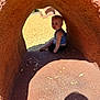 Rowan joined the competition — help win amazing prizes! toddler, child, playground, tunnel, shadow, sunlight, outdoor, sand, curious, sitting, blue_shirt, play, structure, young, daylight, texture, fun, exploration, park, casual