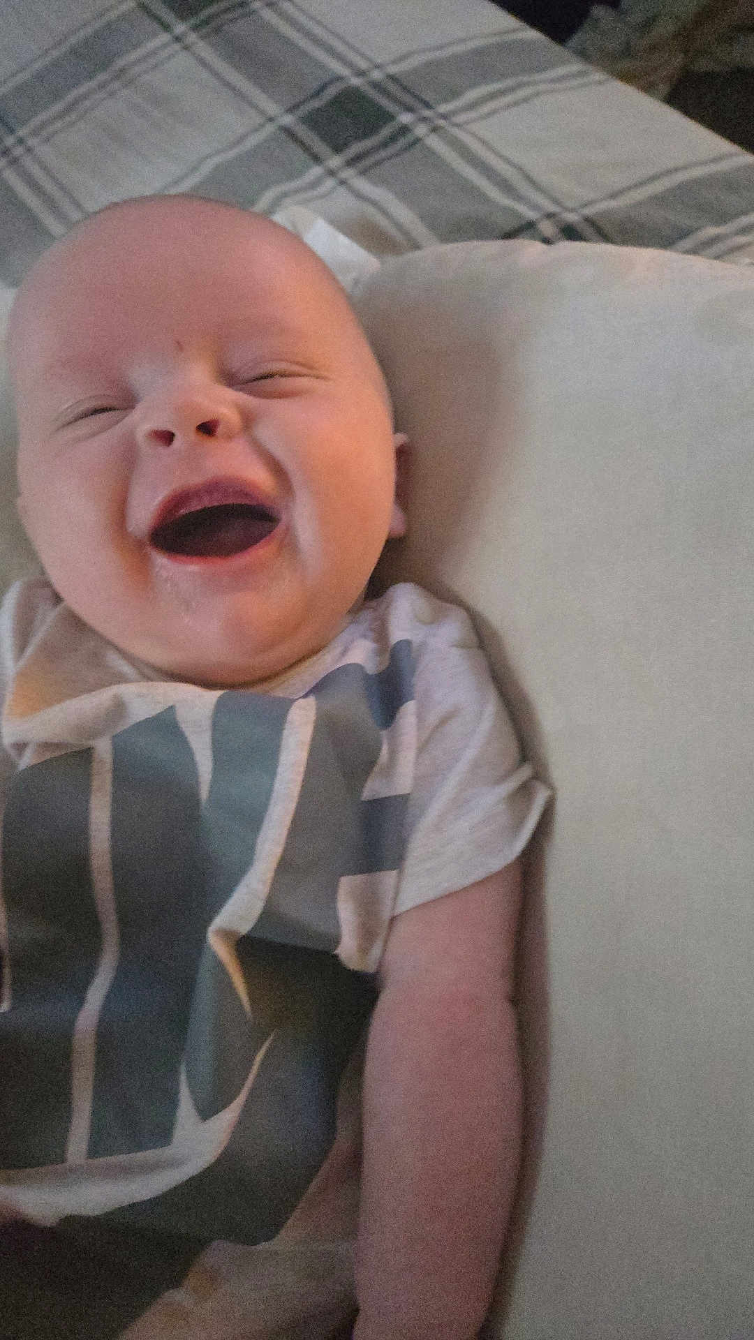 Ryker is registered to the contest to win money with this photo: baby, smiling, infant, happy, face, pillow, plaid, blanket, clothing, person, child, indoors, cute, young, skin, head, toddler, expression, lying, joyful