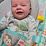 Ryker joined the competition — help win amazing prizes! baby, infant, smiling, pajamas, monkey, baby_rocker, colorful, happy, child, cute, indoors, seat, fabric, pattern, hand, face, clothing, young, comfort, playful