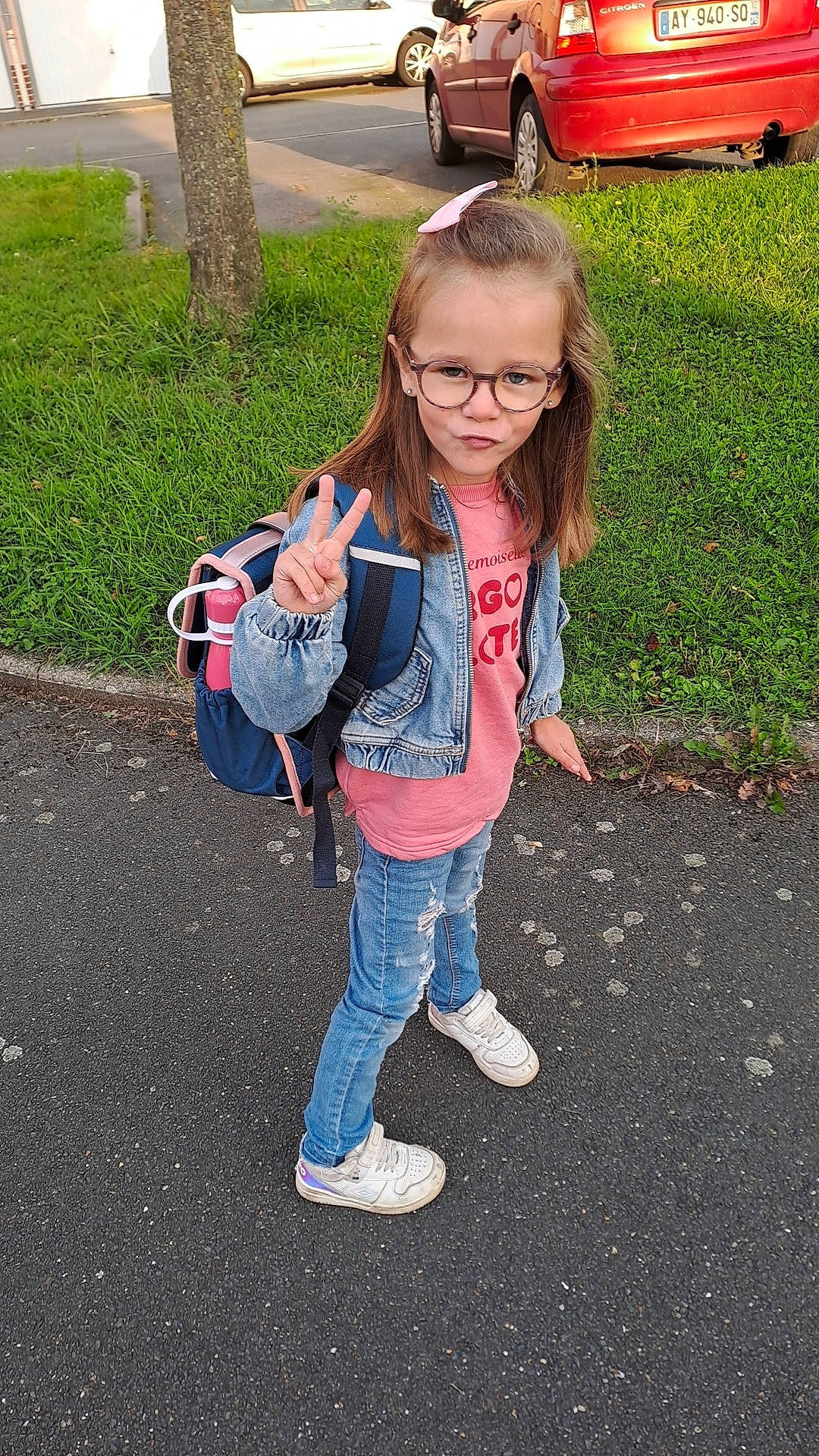 Emy participe au concours pour gagner de l'argent avec cette photo : car, child, clothing, face, female, footwear, girl, grass, head, jeans, machine, pants, person, photography, plant, portrait, shoe, transportation, vehicle, walking