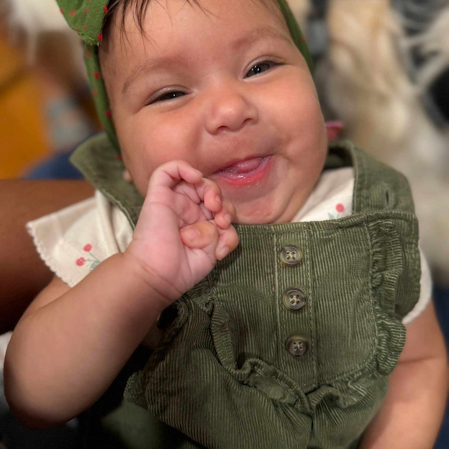 Alana Celine is registered to the contest to win money with this photo: baby, bracelet, buttoned_outfit, child, closeup, clothing, corduroy, cute, expression, face, green_bow, hand, happy, headband, indoors, infant, person, portrait, skin, smiling