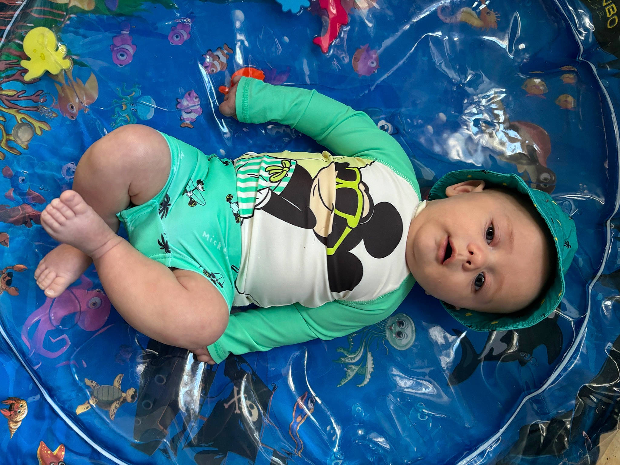 Lyam a rejoint le concours — aidez-le/la à gagner de superbes lots ! aqua, baby, baby_products, baby_toddler_clothing, child, electric_blue, fun, happy, hat, leisure, pattern, person, personal_protective_equipment, play, recreation, sportswear, t_shirt, toddler, tree, water