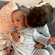 Laël participe au concours pour gagner de l'argent avec cette photo : toddler, child, kiss, couch, pillow, cat, gray_clothing, indoor, cute, affection, cozy, baby, sitting, plush, home, love, furniture, person, cuddle, nap