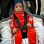 Laël a rejoint le concours — aidez-le/la à gagner de superbes lots ! baby, infant, car_seat, orange_tracksuit, blue_hat, straps, cushion, blanket, clothing, person, indoor, footwear, socks, baby_clothes, face, small_hands, seated, cute, child, safety