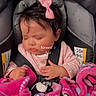 baby, infant, sleeping, car_seat, pink_bow, blanket, pink_blanket, child, cute, peaceful, strapped_in, clothing, indoors, seatbelt, soft_texture, adorable, face, young_child, resting, portrait