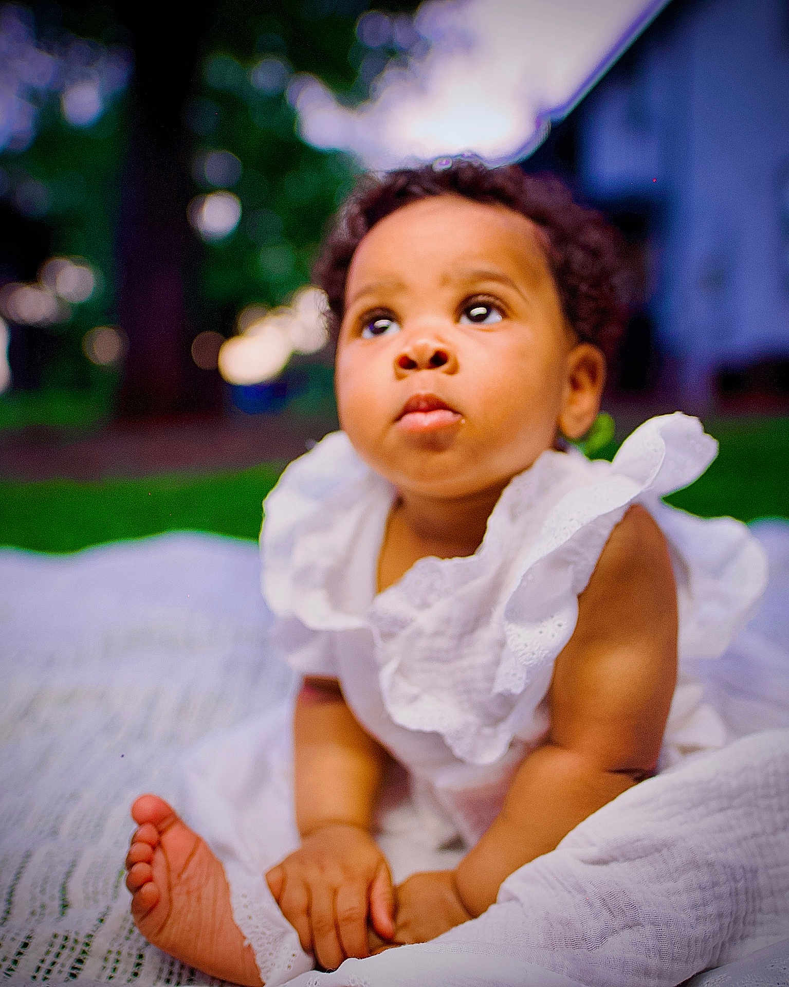 Elaya is registered to the contest to win money with this photo: baby, child, outdoor, white_dress, blanket, grass, curious, portrait, bokeh, hands, feet, infant, sitting, cute, skin, nature, daylight, expression, young, person