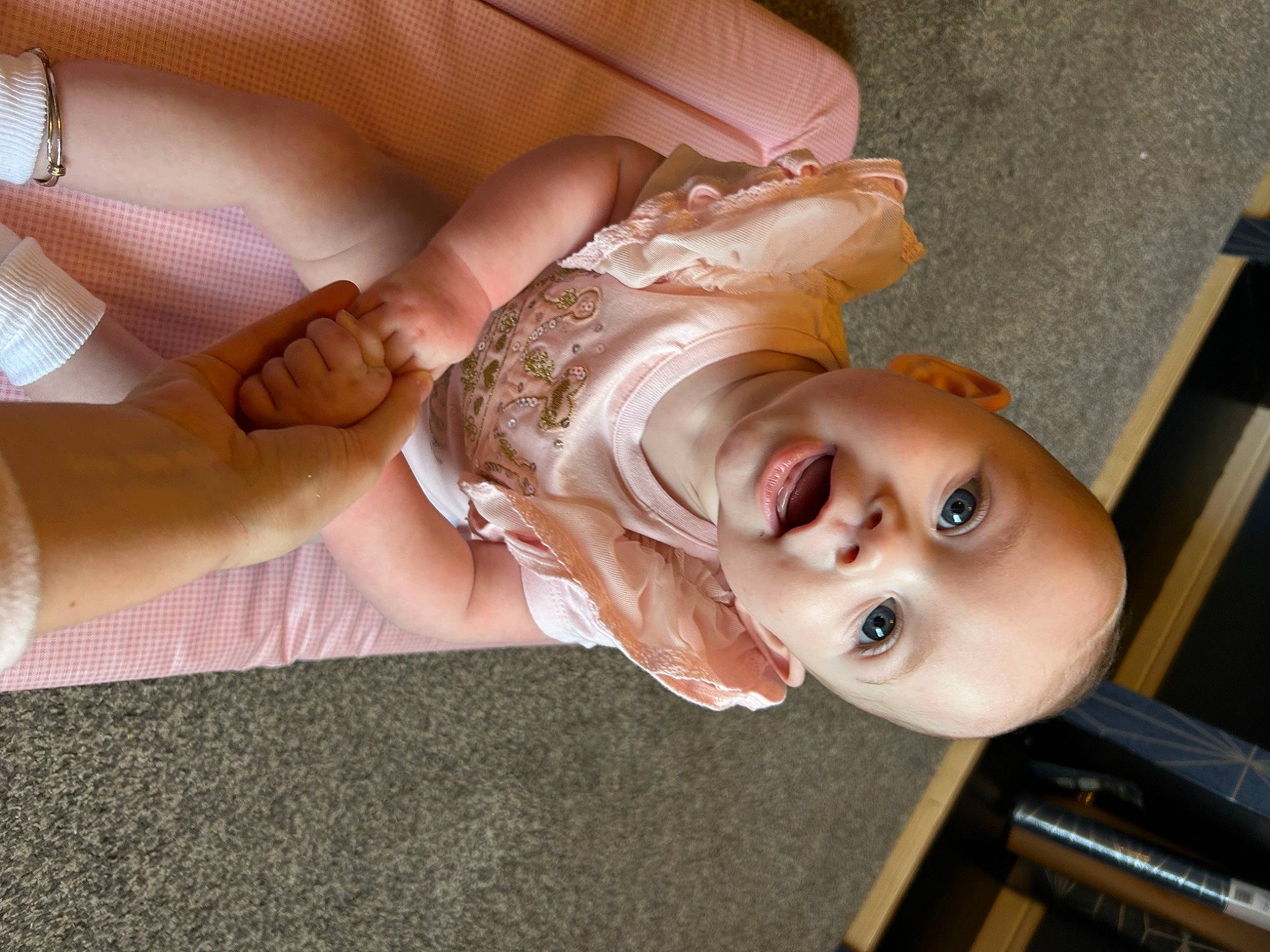 Esmè is registered to the contest to win money with this photo: baby, cheek, child, fashion_accessory, finger, flooring, foot, fun, gesture, hand, happy, human_leg, nail, nose, person, skin, smile, thumb, toddler, wood