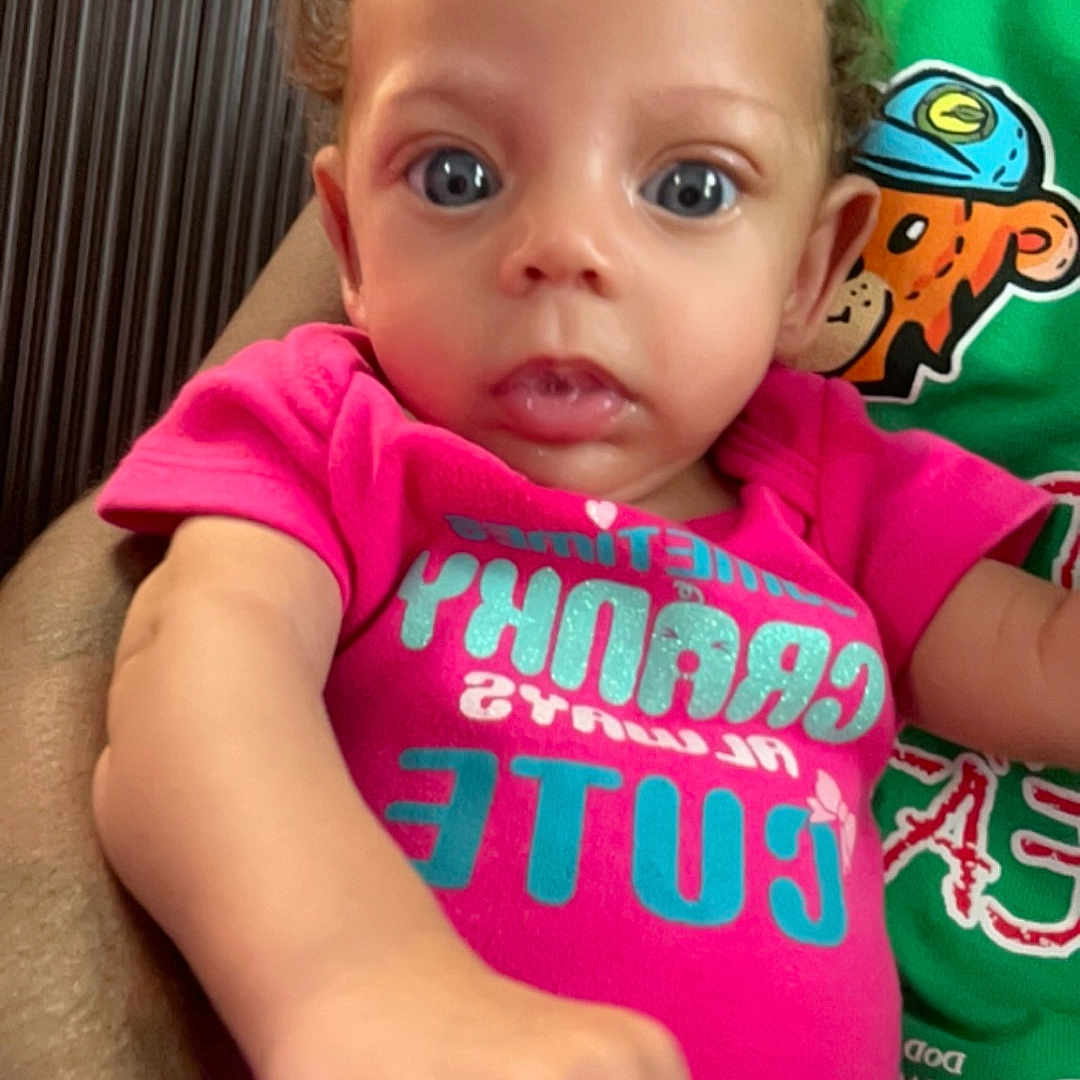 Lailah is registered to the contest to win money with this photo: baby, bodypart, clothing, couch, face, finger, furniture, hand, head, indoors, mouth, person, photography, portrait, selfie, shirt, shorts, sitting, t_shirt, teeth