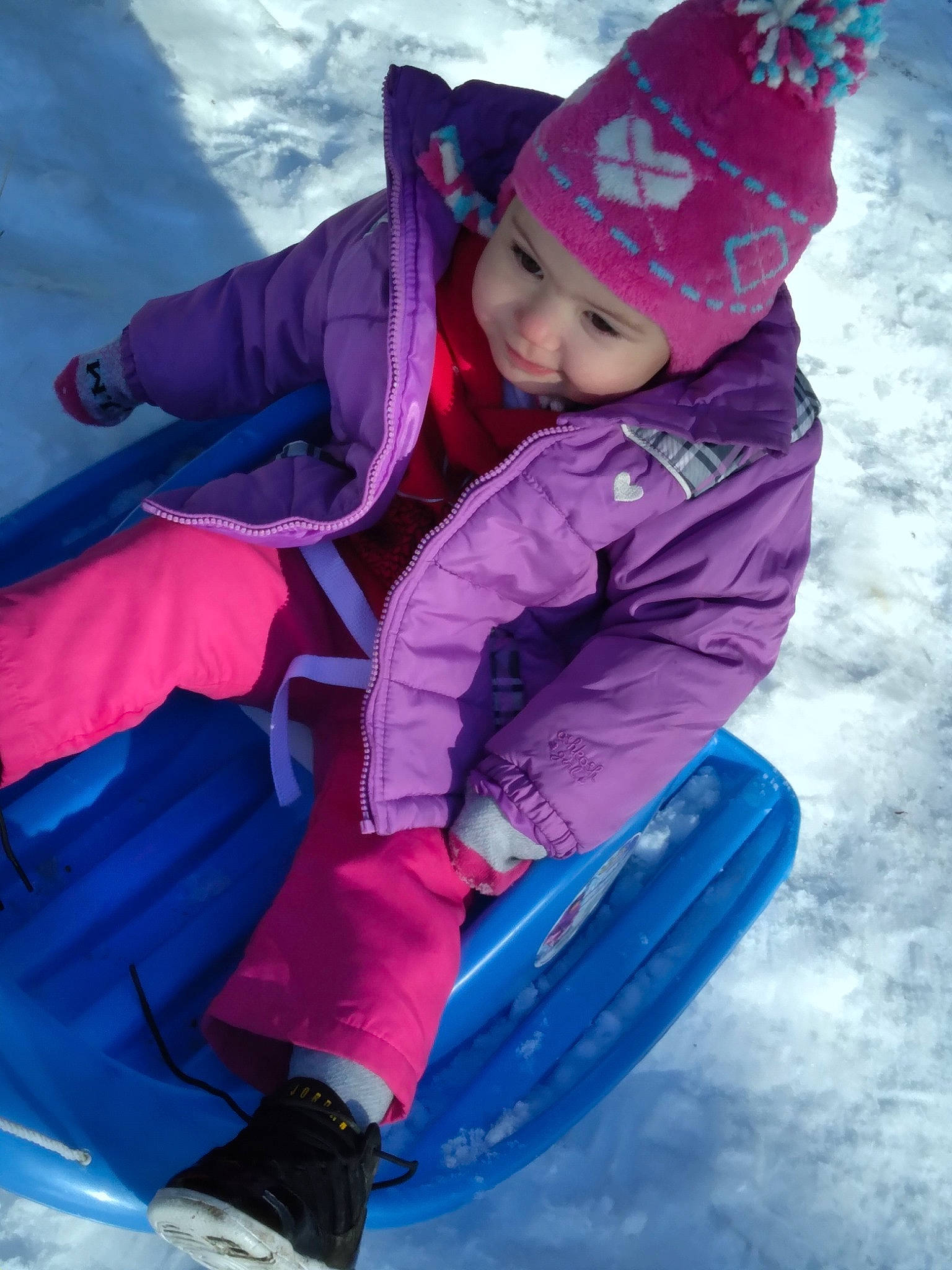 Zendaya is registered to the contest to win money with this photo: baby_toddler_clothing, blue, bonnet, child_model, cool, costume_accessory, freezing, glove, headwear, hood, jacket, magenta, people_in_nature, person, pink, play, playing_in_the_snow, purple, recreation, snow