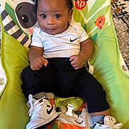Carter joined the competition — help win amazing prizes! animal_print, baby, baby_chair, black_pants, carpet, child, colorful, comfortable, curly_hair, cute, earrings, indoor, infant, nike, playful, sitting, smiling, sneakers, white_onesie, white_shoes