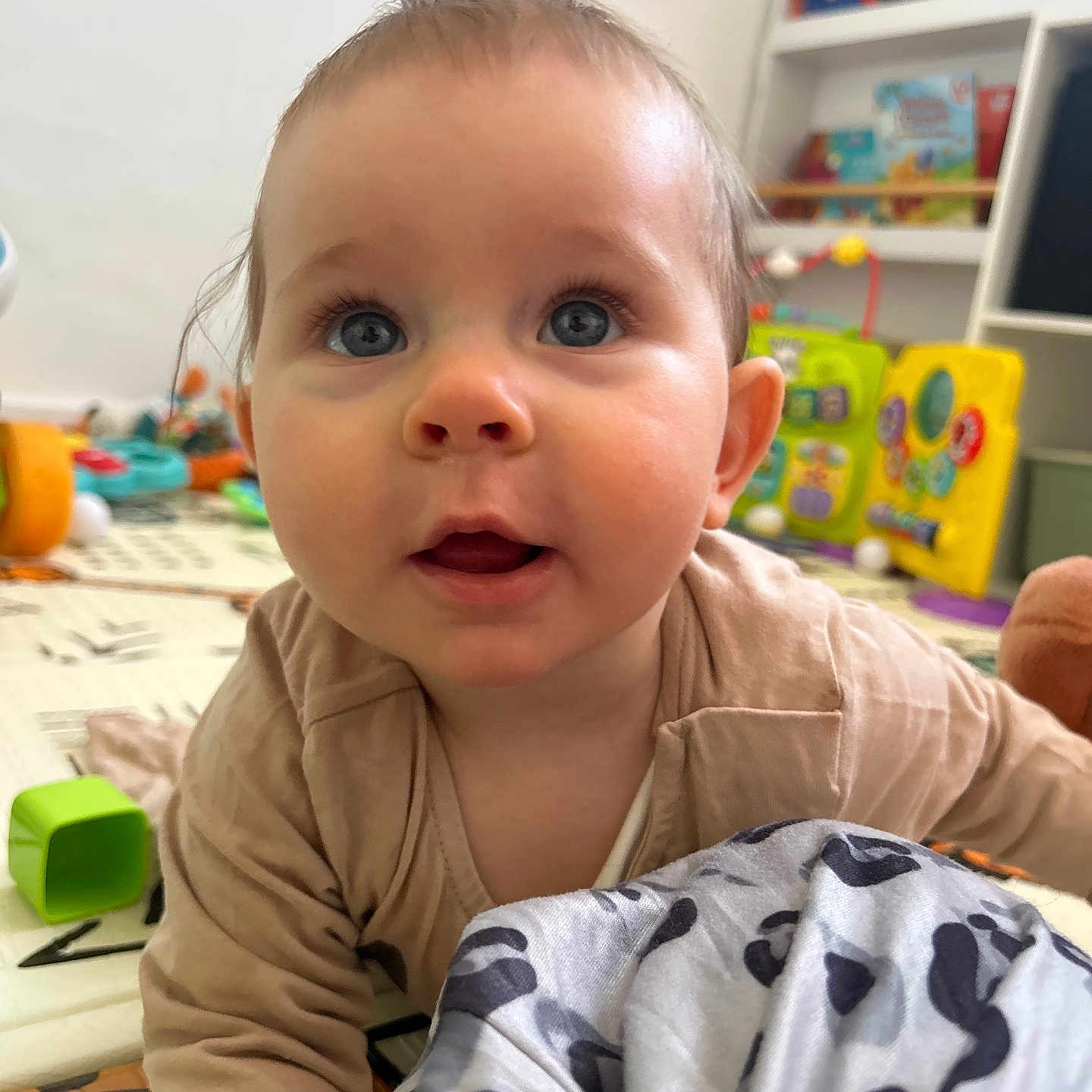 Joy a rejoint le concours — aidez-le/la à gagner de superbes lots ! baby, blanket, blue_eyes, bookshelf, child, clothing, crawling, curious, expression, face, floor, furniture, head, indoor, person, play_mat, room, skin, soft_lighting, toys